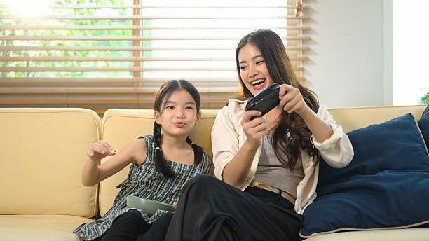 istock Mother teaching her daughter how to play a video game, sharing laughter and learning through fun digital playtime 2240406490