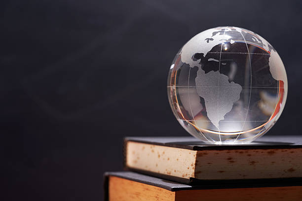 istock glass globe on books against chalkboard as background 2240407557
