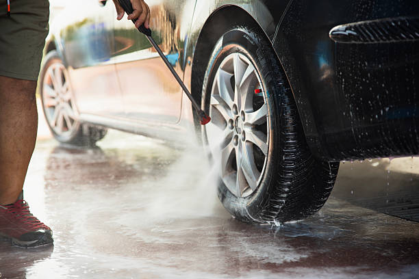 istock Man washing a car tire with 2240408711