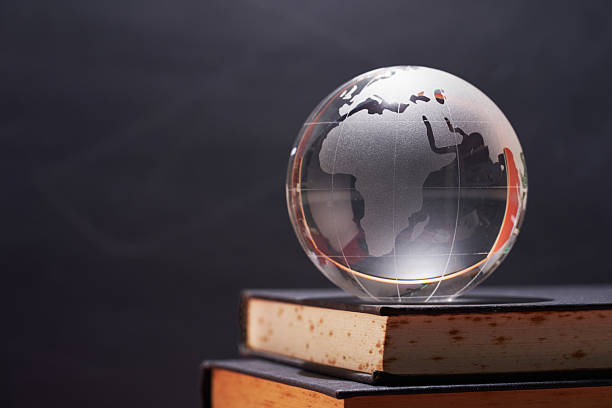 istock glass globe on books against chalkboard as background 2240409524