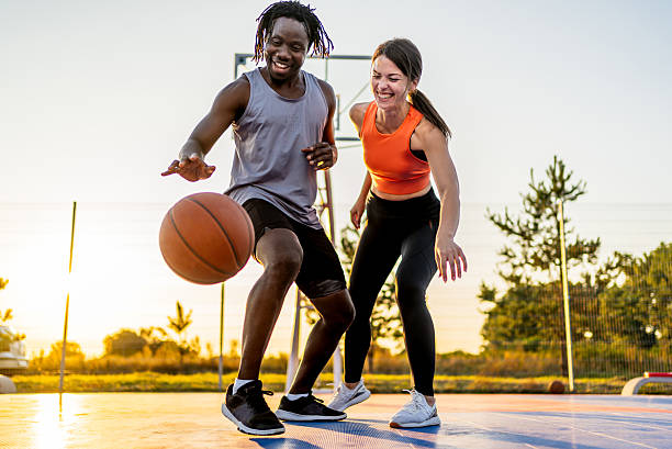 istock Multiracial couple playing basketball outdoors, having fun 2240409712