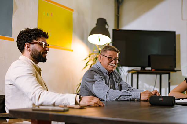 istock Meeting in a modern office setting with focused discussions among colleagues of various backgrounds late in the afternoon 2240412842