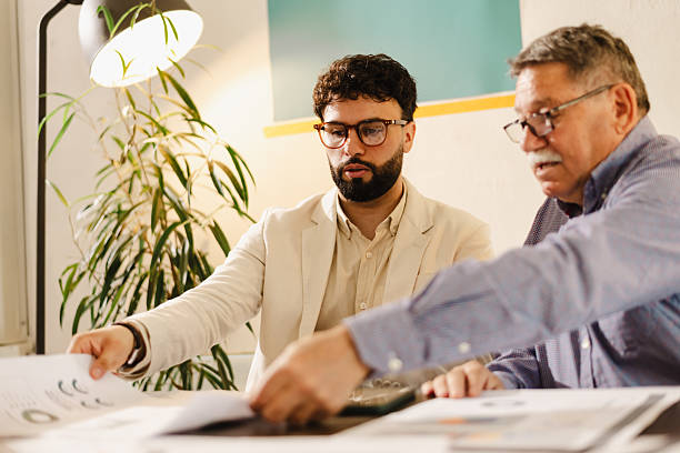 istock Business meeting with two professionals discussing documents in a bright office setting during the daytime 2240412872