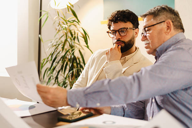 istock Two men working together in an office space, discussing documents while surrounded by greenery and natural light in the afternoon 2240412886