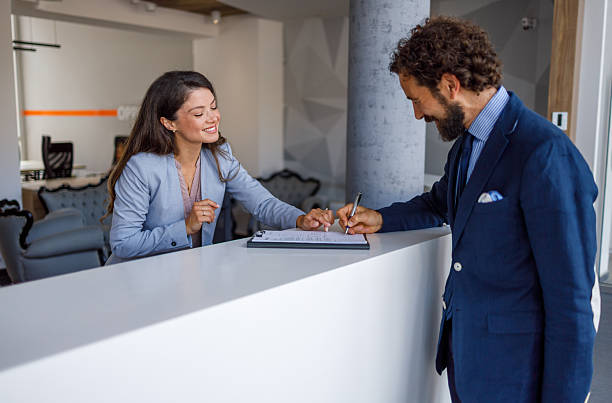 istock Business people completing paperwork at a hotel counter 2240415633
