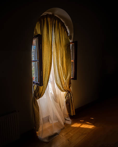 istock Arched window with curtains and sunlight in interior 2240417682