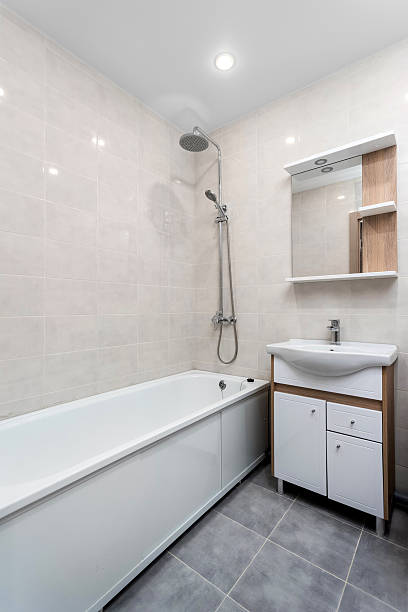 istock Bathroom interior with a white bathtub, a sink with a vanity unit, and a mirror. 2240417880