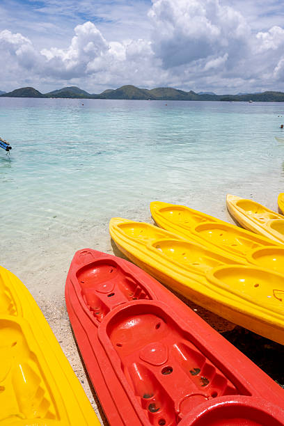 POV past kayaks on beach and tropical lagoon, Palawan