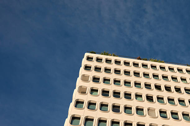Urban building showing a repeating pattern of square windows with rounded corners under a clear sky