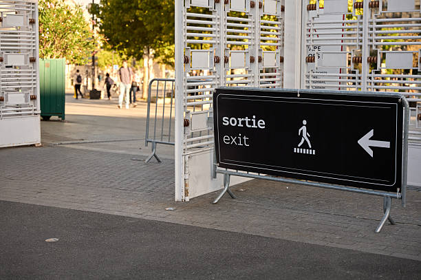Exit sign in french and english indicating direction for people leaving an event venue