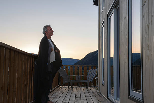 istock Mature man wrapped in blanket on chalet deck 2240432962