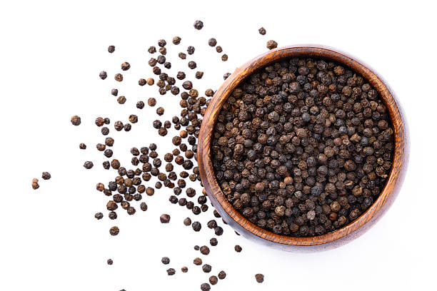 istock Black peppercorns on white background 2240436547