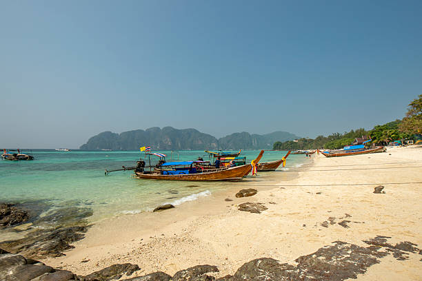 istock Long tail boats moored on a beach on Phi Phi island in Thailand 2240439302