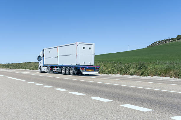 istock A tractor truck driving with a trailer with some prefabricated construction sheds 2240452202