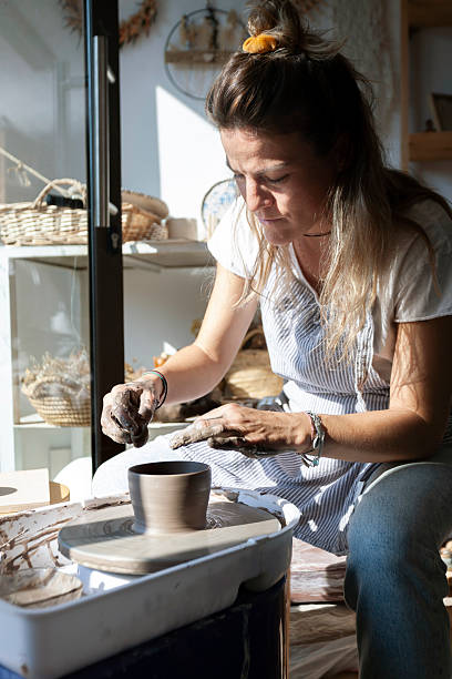 istock Woman working on clay piece in sunlit pottery studio 2240452443