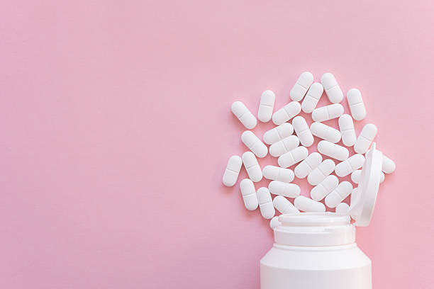 istock Tabletten or pillen in white plastic bottle on the pink background with place for text. 2240455734