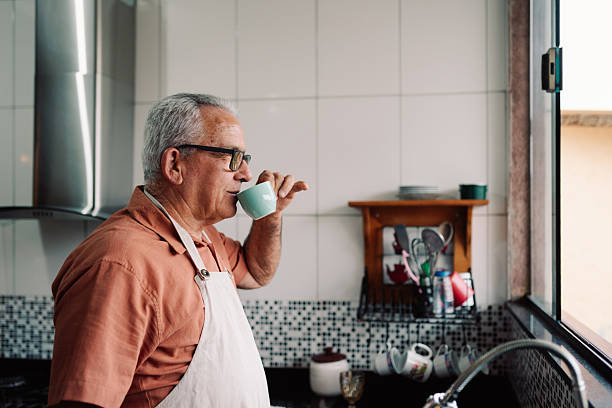 istock Senior man drinking coffee in home kitchen 2240455909