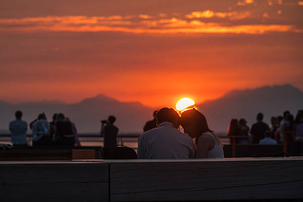 Seattle, USA - Aug 25, 2025: People enjoying a hazy sunset on pier 58.