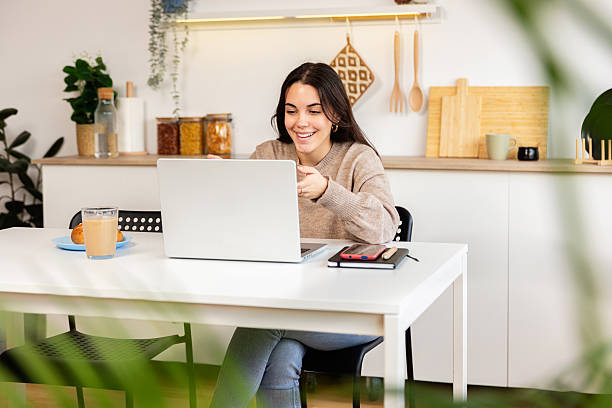 istock Smiling young college student studying remotely from home 2240468741