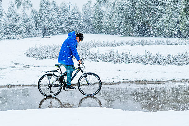 istock Boy Riding Bicycle in Heavy Snowfall During Winter 2240470776