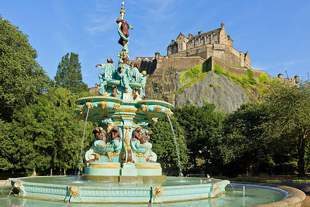 Edinburgh, Scotland - July 16, 2025: Daytime view of the ornate Ross Fountain with Edinburgh Castle rising above Princes Street Gardens in Edinburgh, Scotland. The 19th-century cast-iron fountain is a distinctive feature of the public park below the historic castle.