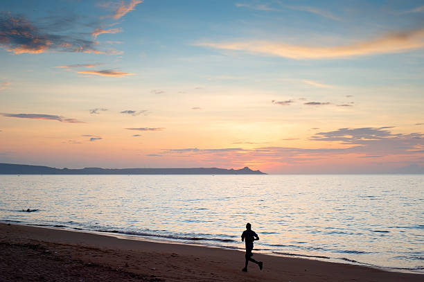 A manjogging on the beach at sunset. Benguela, Angola