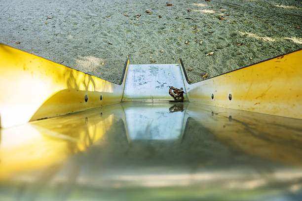 Polished metal ramp leading down a slide in a playground