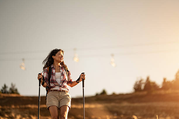 istock Woman hiking on a hill during a beautiful sunset. 2240488454