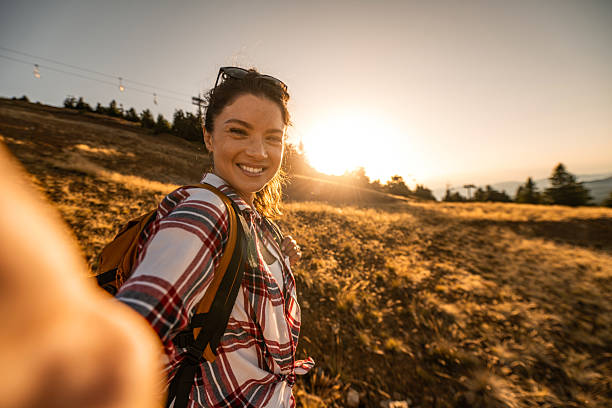 istock Joyful woman hiking on a hill during beautiful sunset. 2240490059