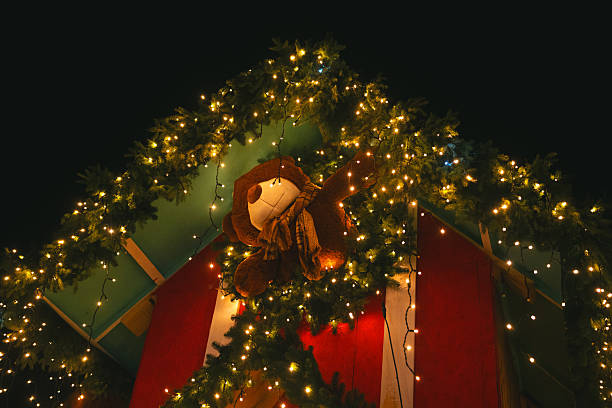 istock Fuzzy toy bear on festive fir tree branches with glowing warm lights at night 2240494709