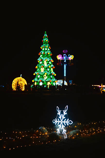 istock Christmas tree bright lights winter night outdoor decorations with snowflake 2240494722