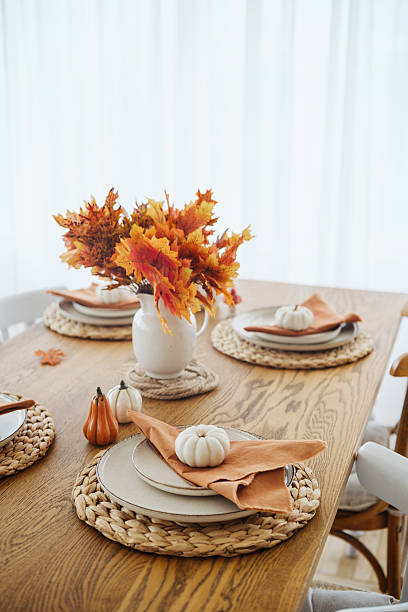 istock Autumn table setting with pumpkins and vibrant maple leaves in vase 2240494837