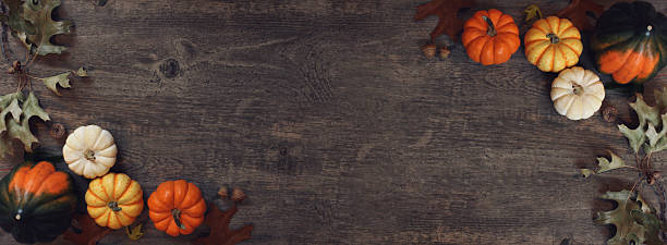istock Fall Thanksgiving Horizontal Background Frame with Pumpkins and Leaves Border Over Dark Wood Texture 2240500023
