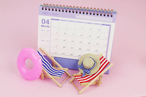 istock Blue and red beach chairs with hat, inflatable ring and calendar on pink background. 2240521722