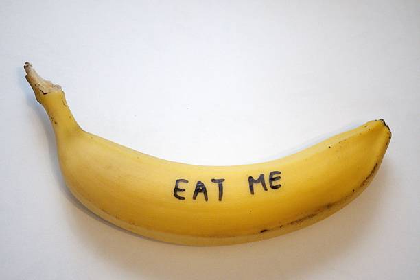 istock Yellow banana with “Eat me” text on white background 2240527462