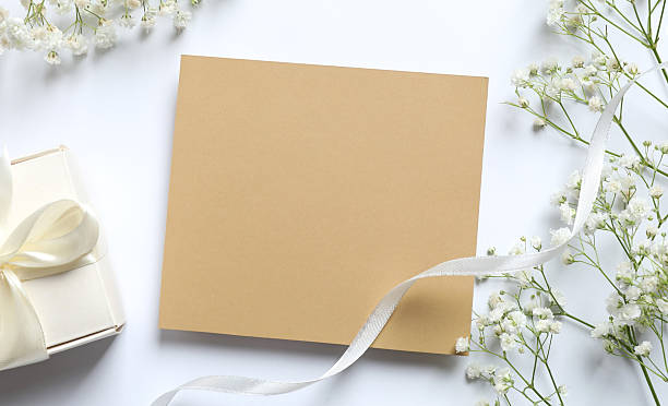 istock wedding invitation card and white envelope with white flowers on a beige textured background. flat lay, top view. 2240528204