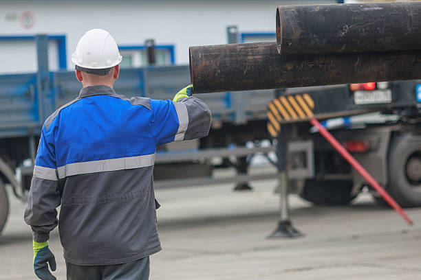 istock Worker Handling Steel Pipes at Construction Site 2240536649