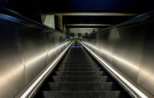 A View Looking Down A Set Of Escalators Descending Down Into The London Underground Tunnels