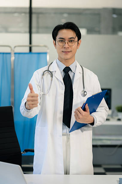 istock Successful male doctor standing at table, looking at camera. 2240542546
