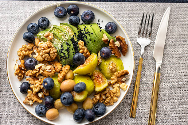 Healthy breakfast bowl with avocado, figs, berries, and walnuts