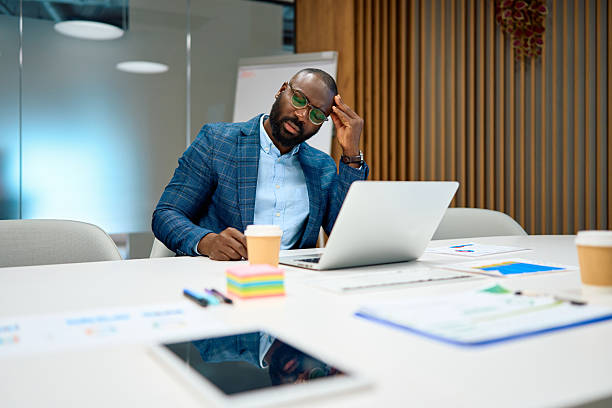 istock Stressed businessman feeling headache at office desk using laptop 2240544973