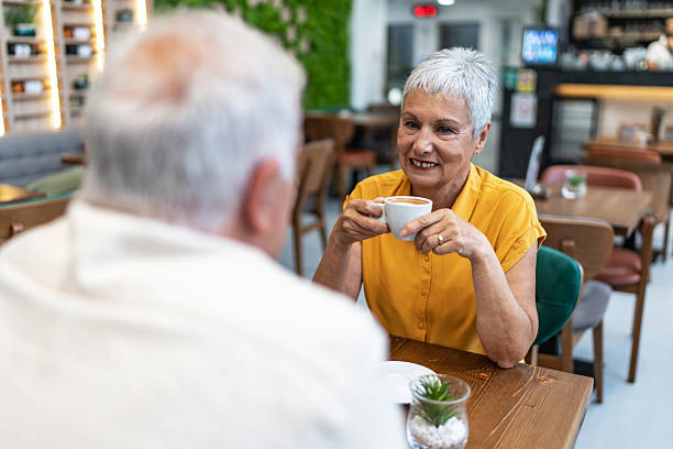 istock Senior couple enjoying conversation and coffee in cafe 2240546698