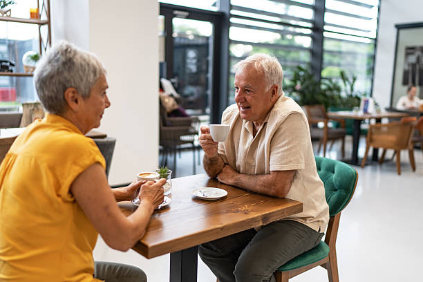istock Senior couple enjoying conversation and coffee in a modern cafe 2240546742