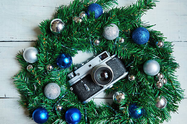 An old camera and Christmas decorations on a wooden surface. Vintage elements and the main holiday of the year.