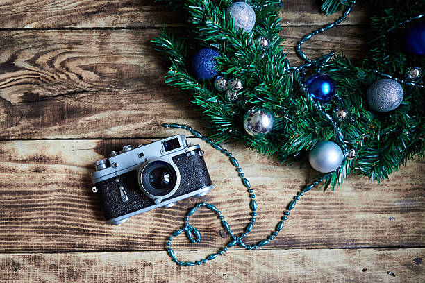 istock An old camera and Christmas decorations on a wooden surface. Vintage elements and the main holiday of the year. 2240547568
