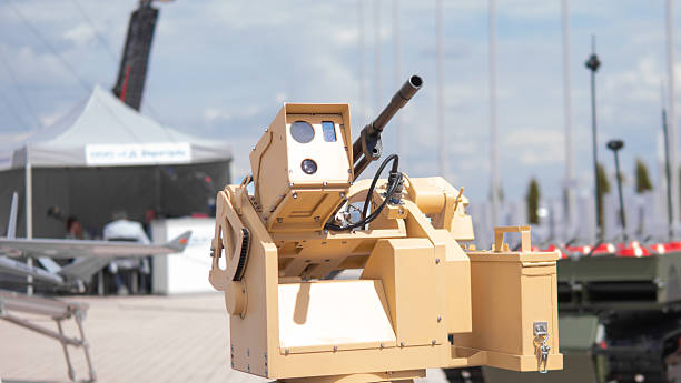 Military Drone With Mounted Gun Displayed at Defense Expo in Urban Setting Under Bright Sky, Showcasing Advanced Warfare Technology and Innovation