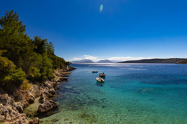 Serene Mediterranean Cove with Clear Blue Waters and Small Boats on the Greek island of Lefkada