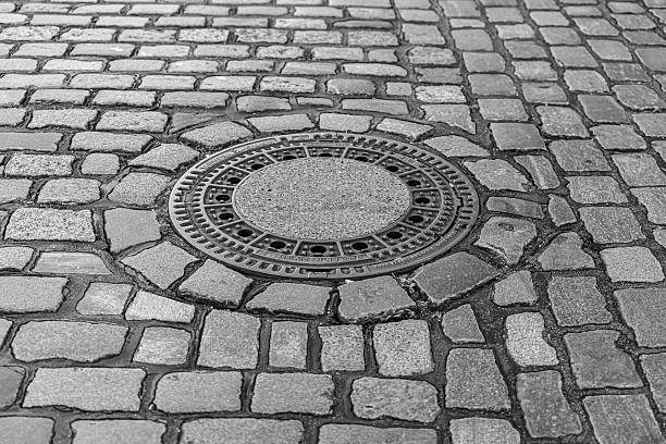 Cobblestone pavement with stone manhole cover