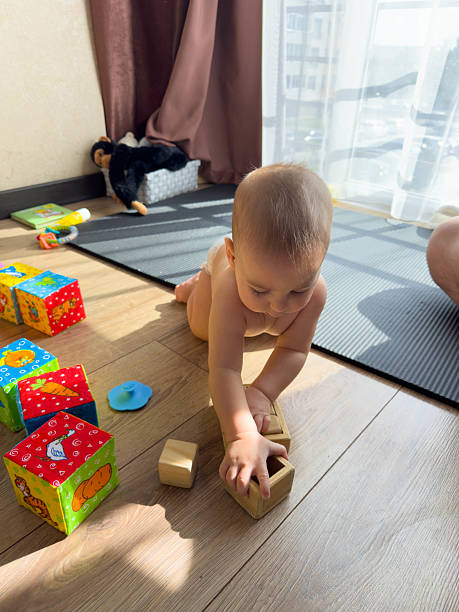 istock Baby Playing with Wooden Blocks on Floor 2240550187