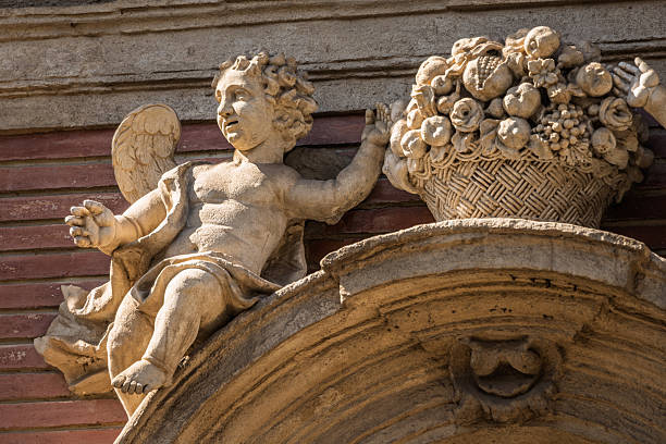 A putto next to a fruit and flower basket graces the San Luis de los Franceses facade in Seville, reflecting baroque art and innocence.